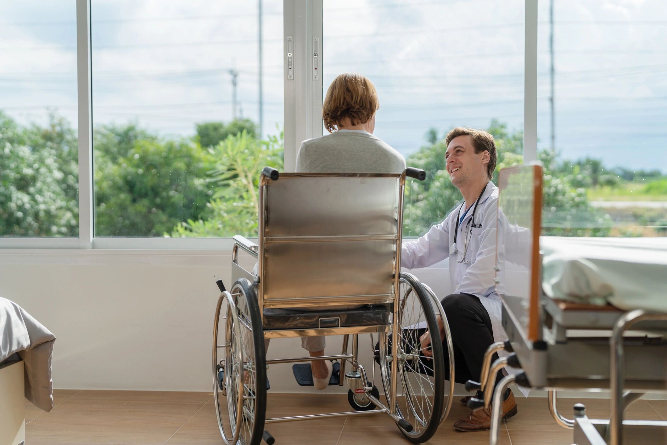 Caregiver supporting elderly woman in wheelchair